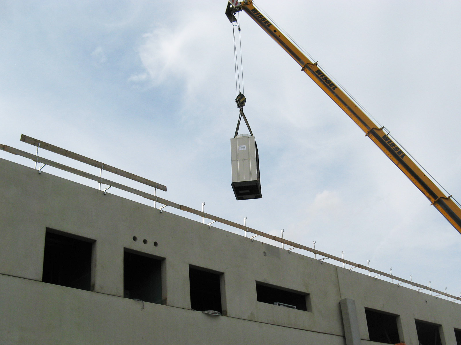 Bauteile einer Klimaanlage von Maik Werner - Kälte und Klimatechnik werden mit Hilfe eines Krans auf ein Dach transportiert
